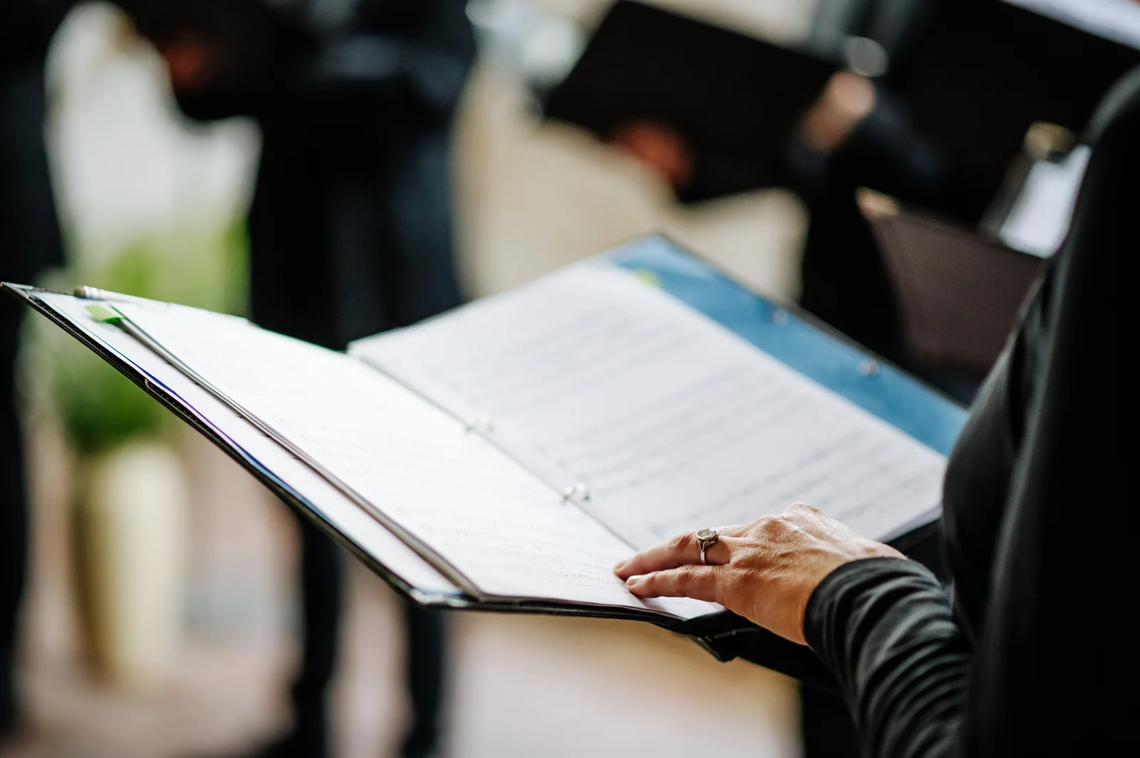 Hands holding a printed workbook open to a notes page